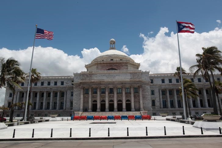 The flags of the U.S. and Puerto Rico fly outside the Capitol building in San Juan