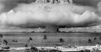 grayscale photo of explosion on the beach